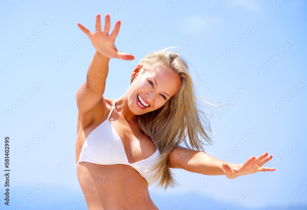Loving the summer sun and feeling amazing. A beautiful young woman with her arms outstretched at the beach.