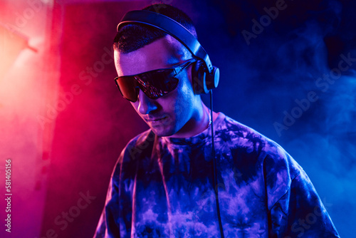 Club DJ playing music at party wearing sunglasses