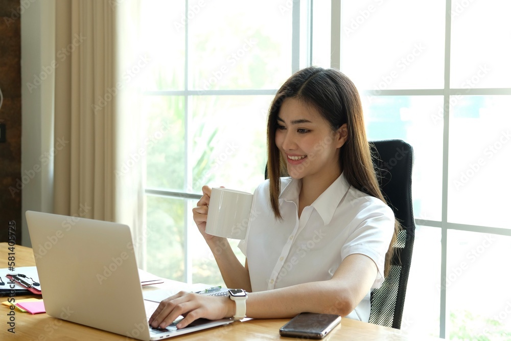 Smiling beautiful young asian woman working on laptop Smiling beautiful young asian woman working on laptop