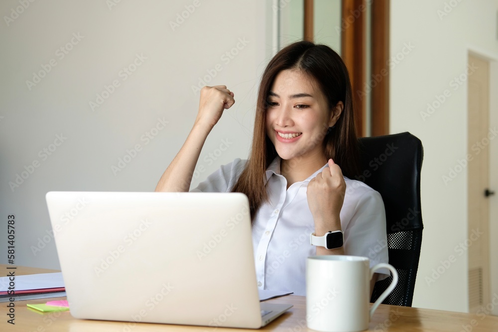 Portrait of Happy Excited young asian woman at workplace office desk, successful Asian female reading good news technology online, employee freelance finance concepts. Portrait of Happy Excited young asian woman at workplace office desk, successful Asian female reading good news technology online, employee freelance finance concepts.