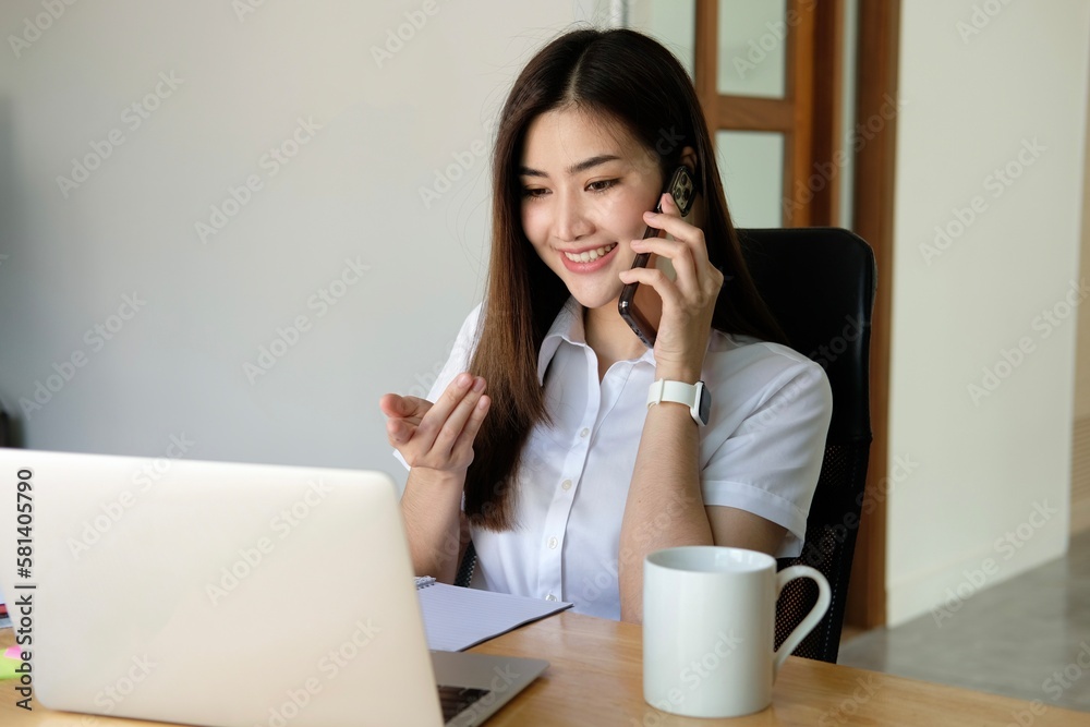 Asian business woman have the joy of talking on the phone, laptop and tablet on the office desk. Asian business woman have the joy of talking on the phone, laptop and tablet on the office desk.