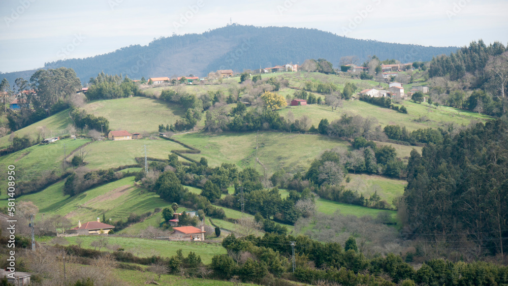 Casas rurales en colinas verdes de valle de Asturias