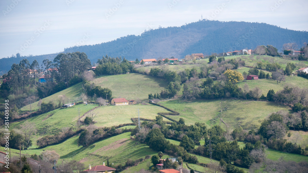 Casas rurales en colinas verdes de valle de Asturias