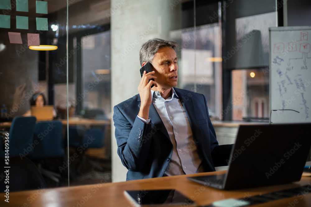 Businessman in office. Handsome man talking on phone at work. Businessman in office. Handsome man talking on phone at work.