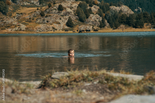 Un niño bañándose en un lago de montaña   photo