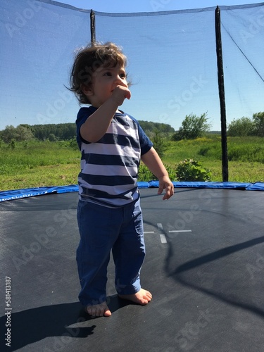 smiling happy joyful child on the playground playing on the trampoline jumping