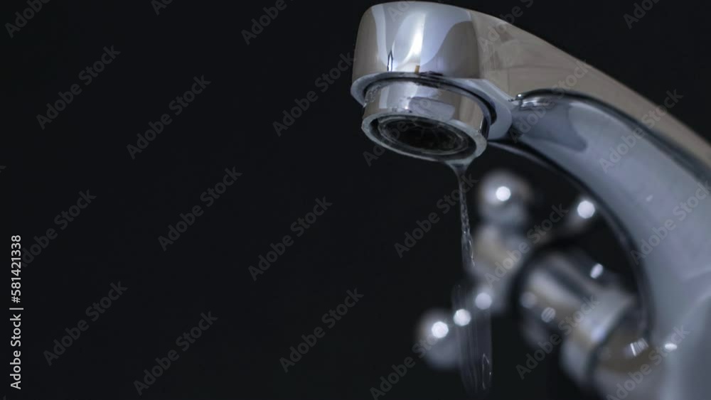 close up of dripping faucet with black background close up of dripping faucet with black background