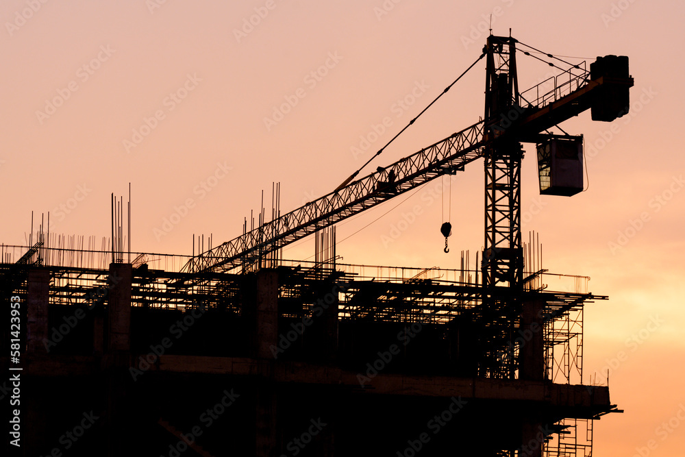 Silhouette construction site on sunset in evening time.Engineer and worker on building site.Construction sites and cranes are working in the industry new building business.