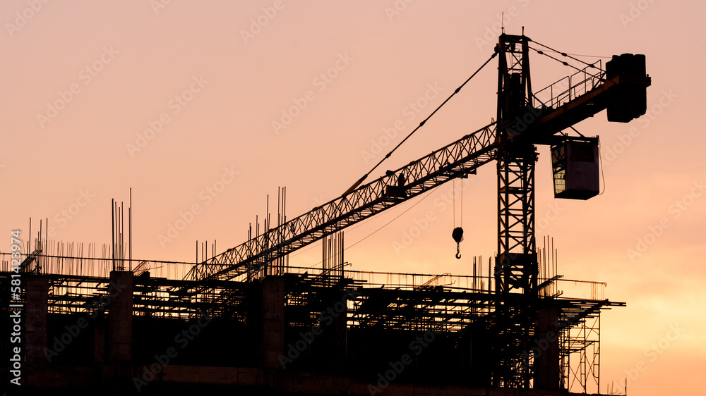 Silhouette construction site on sunset in evening time.Engineer and worker on building site.Construction sites and cranes are working in the industry new building business. Silhouette construction site on sunset in evening time.Engineer and worker on building site.Construction sites and cranes are working in the industry new building business.