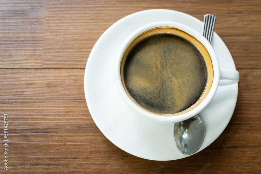 Fototapeta premium Top view Hot coffee in the white cup on wooden table background..Cafe drinking menu black coffee at the restaurant with copy space.