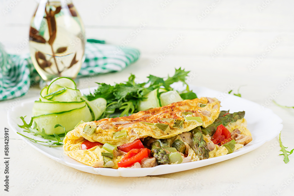 Keto breakfast. Omelette with chicken fillet, tomatoes and asparagus on white wooden table. Italian frittata. Keto, ketogenic lunch. Keto breakfast. Omelette with chicken fillet, tomatoes and asparagus on white wooden table. Italian frittata. Keto, ketogenic lunch.