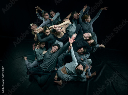 Top views of group of young people dancing contemp style against black studio background. Unique. Concept of modern freestyle dance, contemporary art, movements, hobby and creative lifestyle