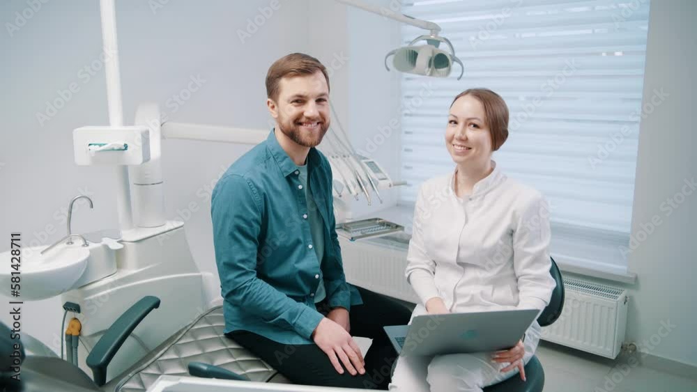 A female doctor discusses a dental restoration and rehabilitation plan with a patient on laptop