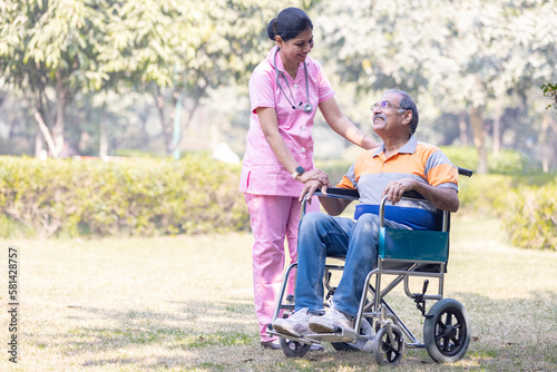 Photography Female nurse with senior man in wheelchair admiring view at park