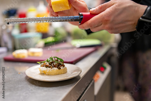 man chef hand cooking tapas with tapenade and cream cheese on restaurant kitchen