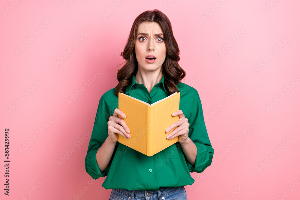 Photo of horrified frightened cute woman wavy hairdo dressed green shirt hold holding book impressed novel isolated on pink background - obrazy, fototapety, plakaty 