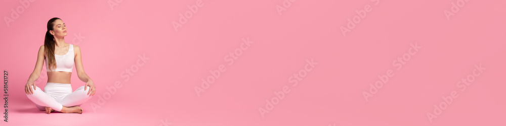 Young, beautiful woman in a white tracksuit practicing yoga meditation in the lotus position isolated on pink background, website banner with space on the right Young, beautiful woman in a white tracksuit practicing yoga meditation in the lotus position isolated on pink background, website banner with space on the right
