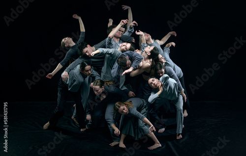 Top view. Young expressive men and women standing close to each other and making performance, dancing contemp over black studio background. Modern freestyle dance, art, movements, creative lifestyle