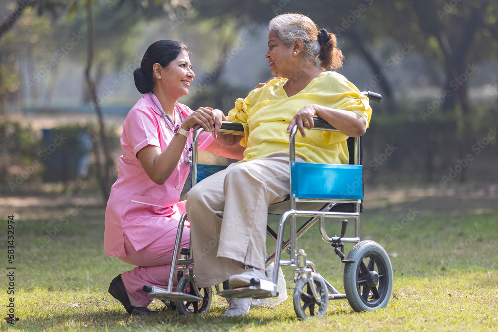 Indian caregiver nurse taking care of senior female patient in a wheelchair  at park. Stock Photo | Adobe Stock