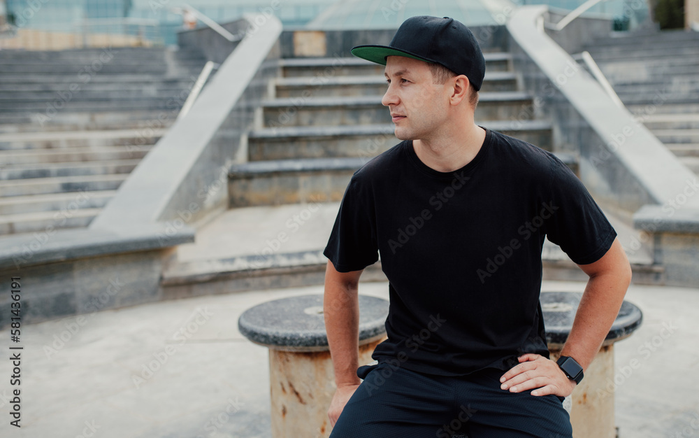 Fototapeta premium Young guy wearing black blank t-shirt and black cap. Mock-up for print. T-shirt template.