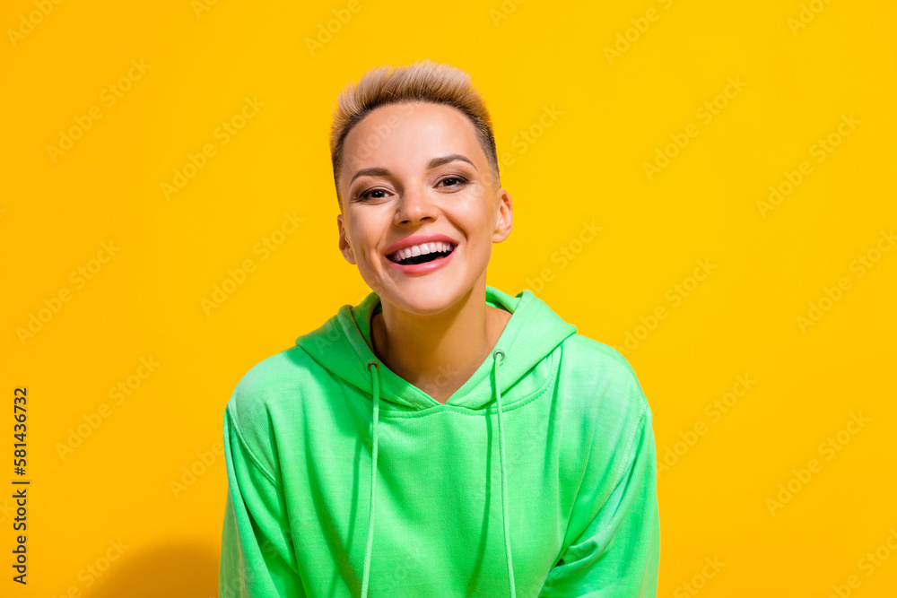 Photo portrait of young positive cheerful lady optimist wearing stylish hoodie looking cameraman rejoice laugh isolated on yellow color background Photo portrait of young positive cheerful lady optimist wearing stylish hoodie looking cameraman rejoice laugh isolated on yellow color background