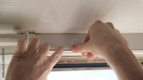 The man wipes the window frame with a degreaser and glues a sealing rubber tape on it for noise insulation, wind protection, weather protection.