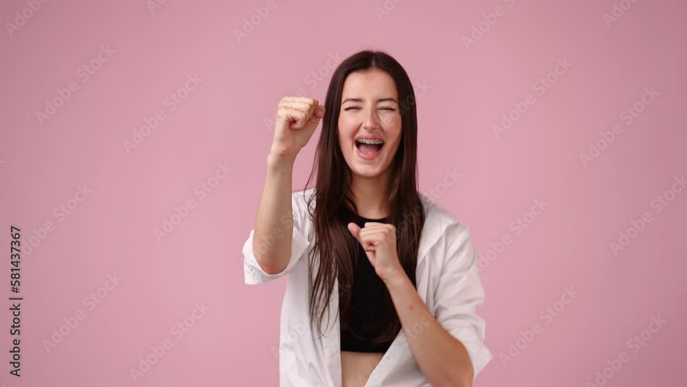 4k video of girl raising hands in surprise looking at camera with big eyes on pink background. 4k video of girl raising hands in surprise looking at camera with big eyes on pink background.