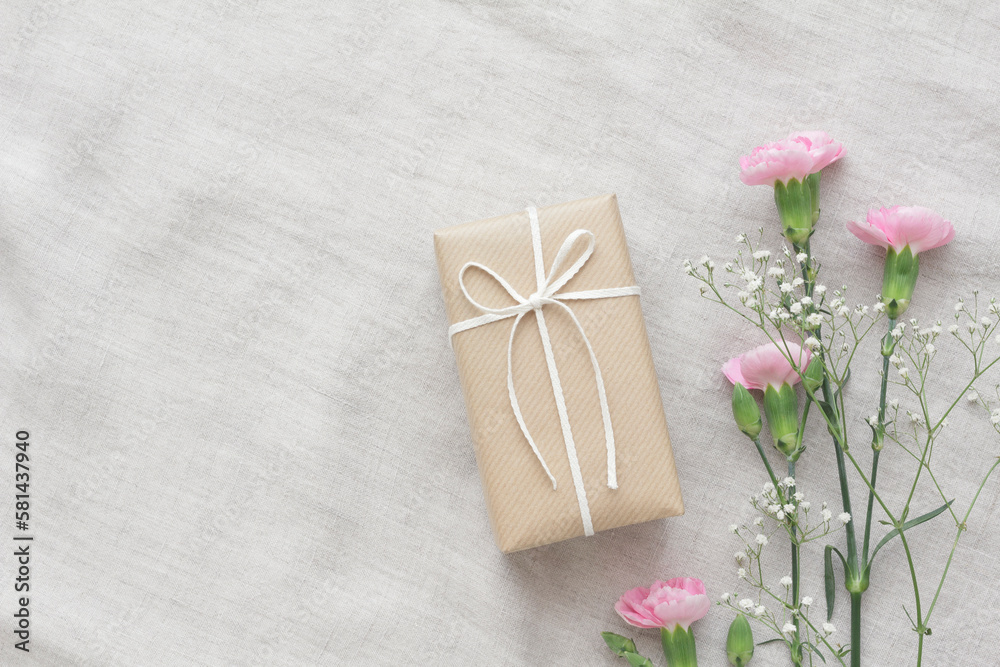 Pink carnations, baby's breath and natural taste present on a gray tablecloth Pink carnations, baby's breath and natural taste present on a gray tablecloth