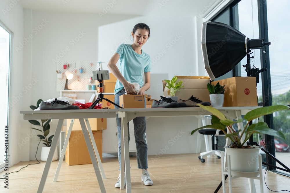 A young woman owner of a small e-commerce business is packing items into the mail box.