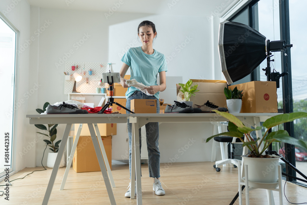 A young woman owner of a small e-commerce business is packing items into the mail box. A young woman owner of a small e-commerce business is packing items into the mail box.