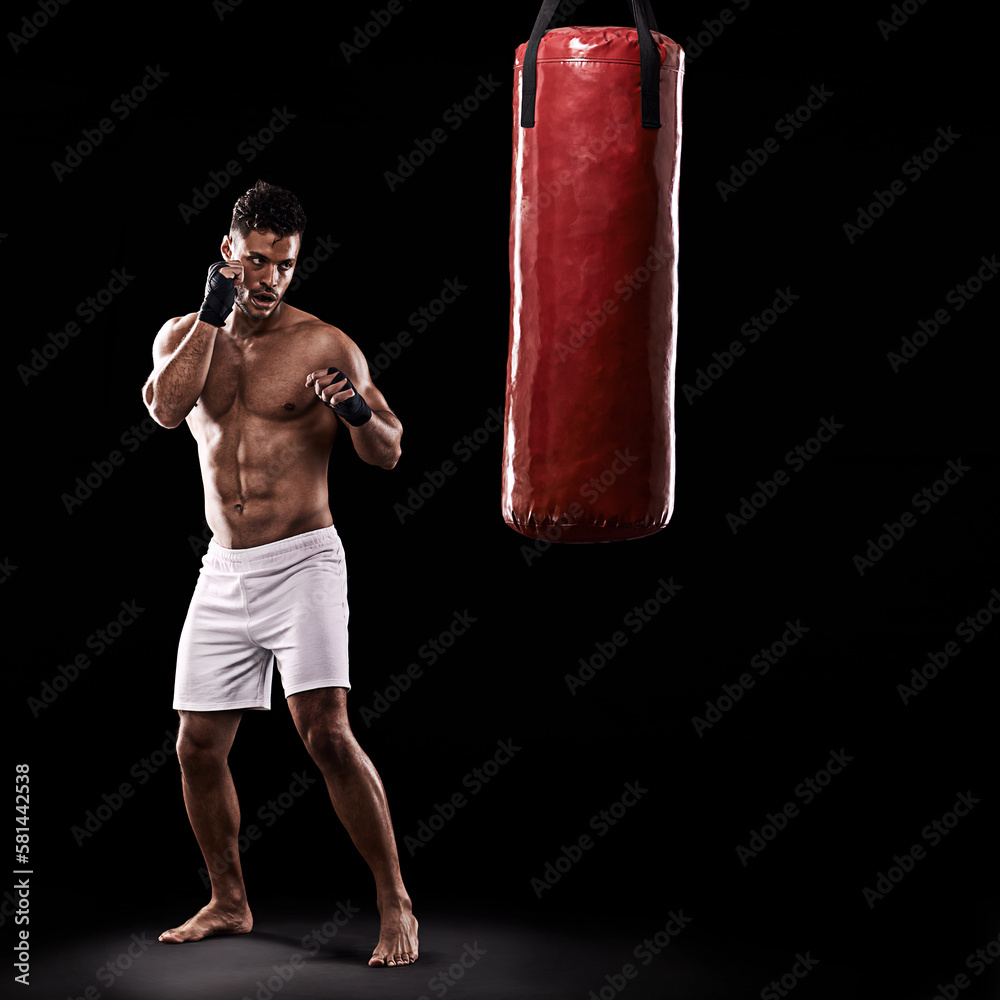 Never let your guard down. Studio shot of kick boxer working out with a punching bag against a black background. Never let your guard down. Studio shot of kick boxer working out with a punching bag against a black background.