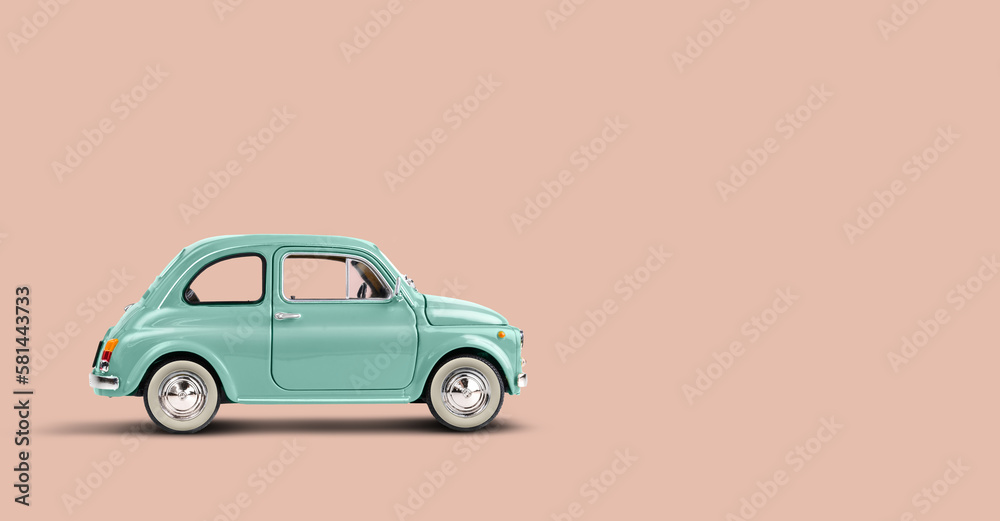 Miniature retro toy car on coral pink background with copyspace - obrazy, fototapety, plakaty 