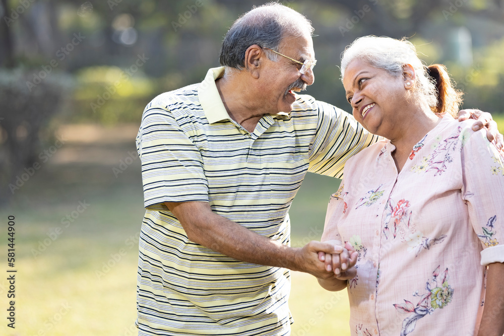 Laughing senior couple spending leisure time at park Laughing senior couple spending leisure time at park