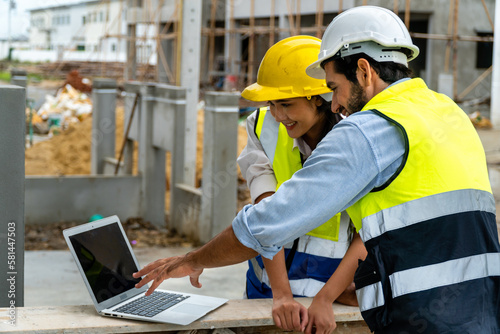 Construction engineer working on laptop on the construction site
