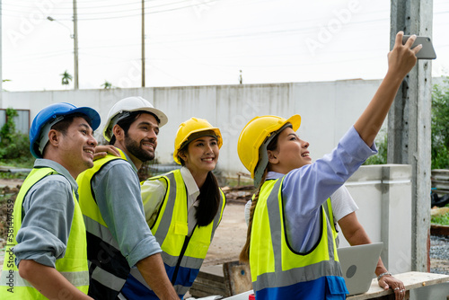 A construction worker taking a selfie with a worker with a cheerful face.