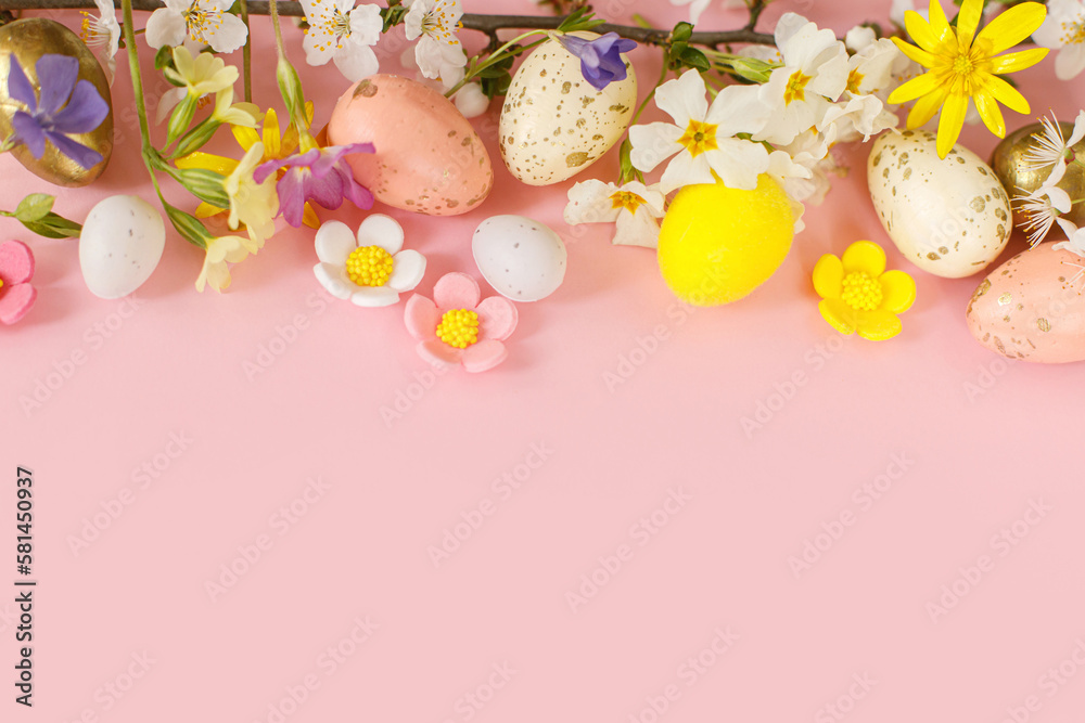 Happy Easter! Easter flat lay with stylish eggs and blooming spring flowers on pink background. Modern template with space for text. Greeting card or banner. Festive border