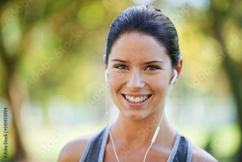Earphones in and ready to run. a young woman wearing headphones.