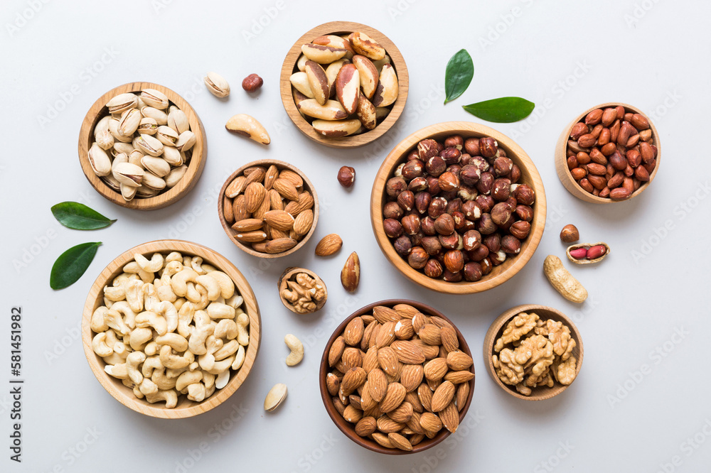 mixed nuts in wooden bowl. Mix of various nuts on colored background. pistachios, cashews, walnuts, hazelnuts, peanuts and brazil nuts mixed nuts in wooden bowl. Mix of various nuts on colored background. pistachios, cashews, walnuts, hazelnuts, peanuts and brazil nuts