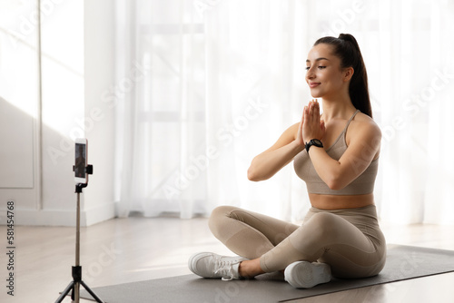 Attractive woman yoga teacher have online class  broadcasting via phone