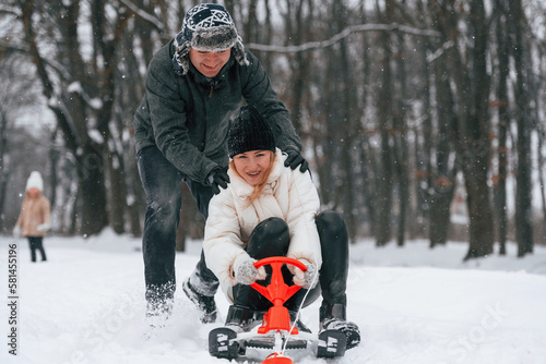 Sled ride. Mother and father is with daughter have walk outdoors at the winter season