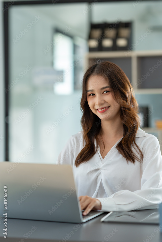 Beautiful Asian businesswoman working on a laptop computer doing financial, accounting analysis, reports, and data at the office. Beautiful Asian businesswoman working on a laptop computer doing financial, accounting analysis, reports, and data at the office.