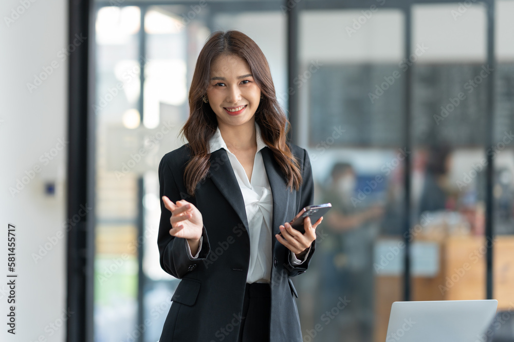 Attractive Asian businesswoman using a mobile phone at the office for making contact Talk about online business. and financial income happily.