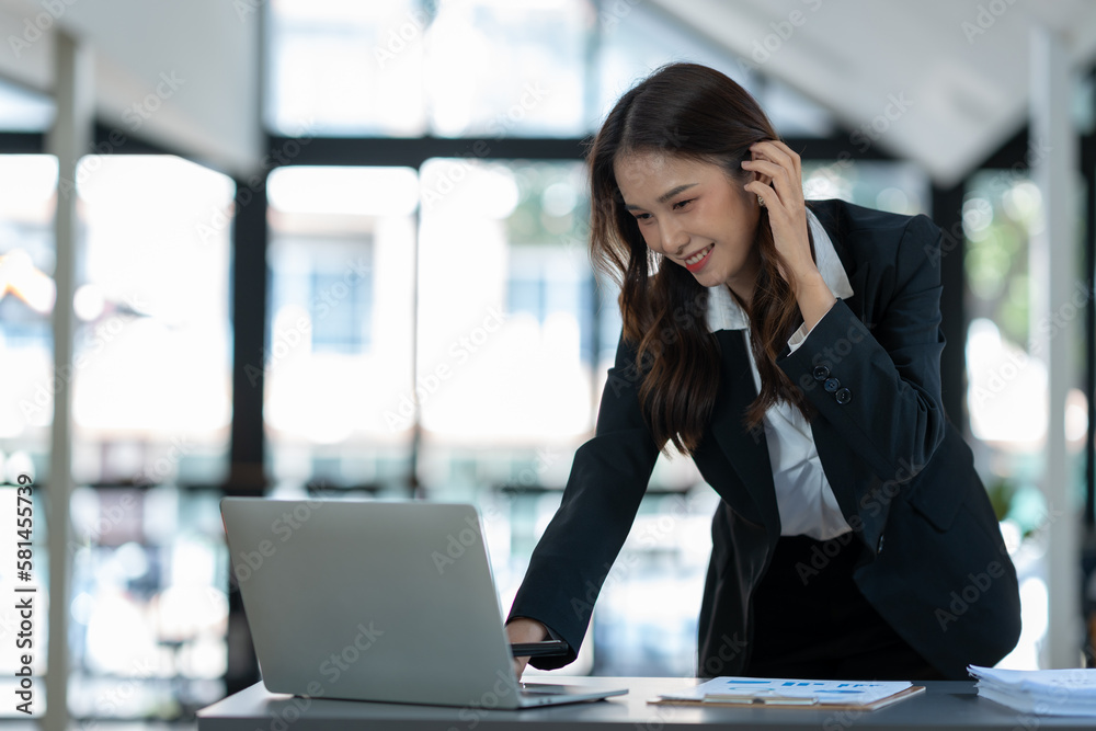 Asian businesswoman using a laptop to communicate Discuss and detail information about jobs online. Finance, accounting, income, and smiling happily at work. Asian businesswoman using a laptop to communicate Discuss and detail information about jobs online. Finance, accounting, income, and smiling happily at work.