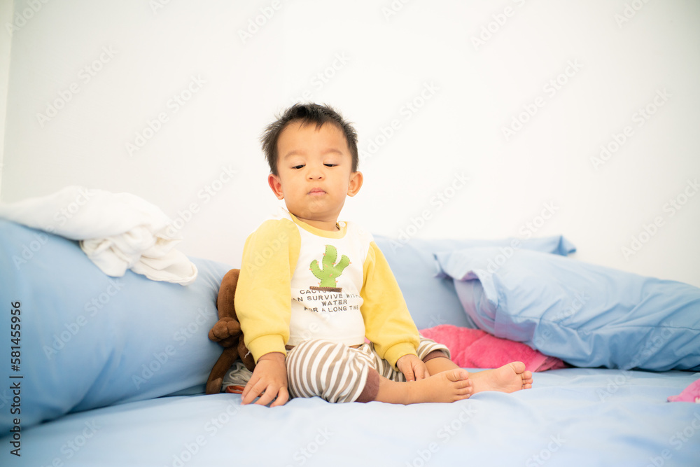 Toddler asian boy wake up on bed in cozy room Toddler asian boy wake up on bed in cozy room