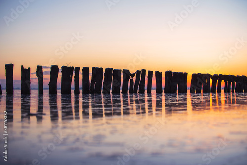 Holz Pfähle im See bei Sonnenuntergang romantisches Panorama