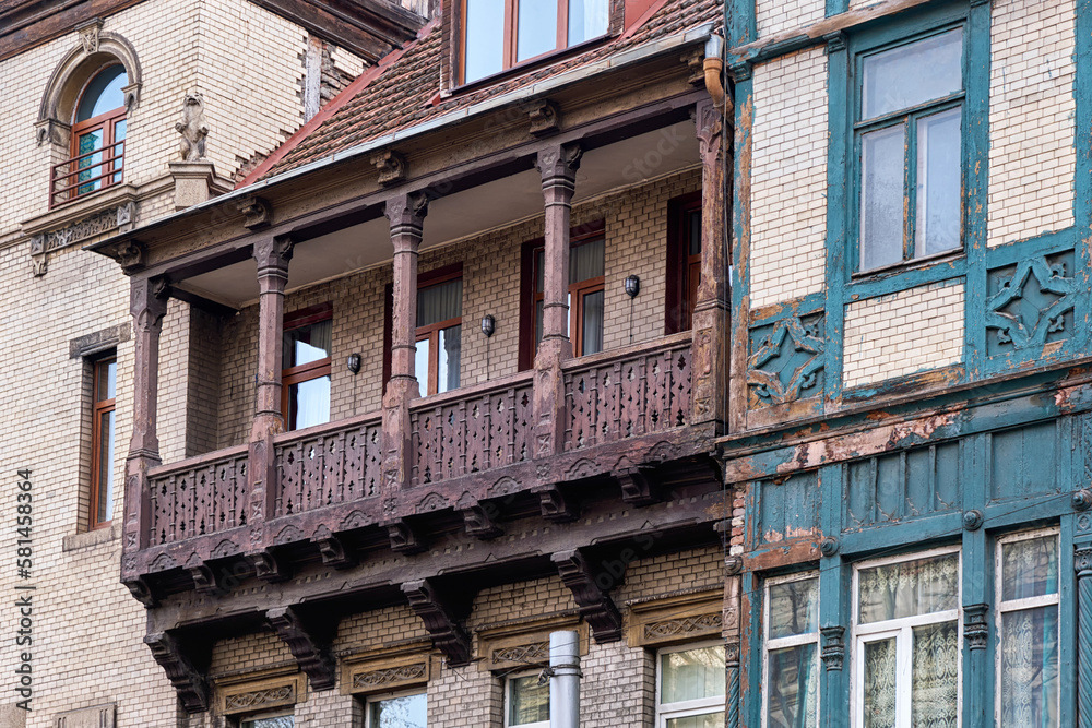 An old wooden balcony with columns on the facade of a building.