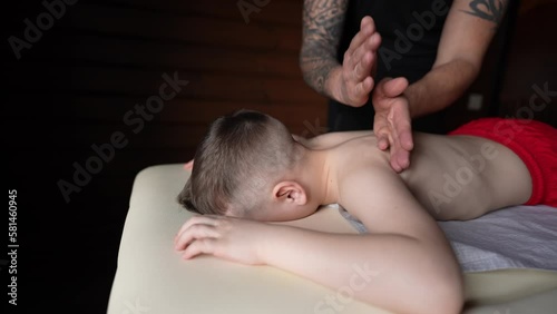 A massage therapist gives a professional massage to a patient photo