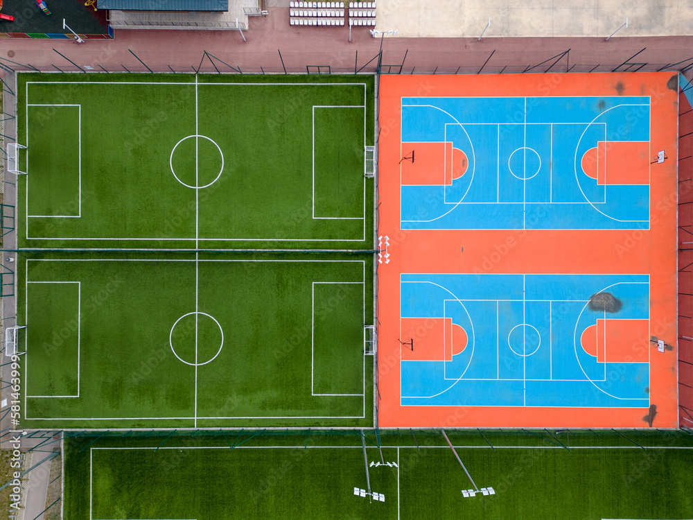 aerial-view-of-a-green-football-field-and-a-colorful-basketball-court