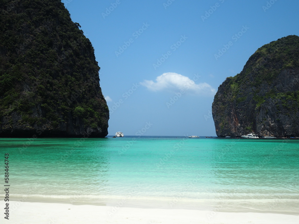 Maya Bay - Beautiful beach in Phi Phi Island.  It is situated in Hat Noppharat Thara in Thailand. Quiet atmosphere beautiful sea, white sand beach, there are motor boats of tourists in the distance.
