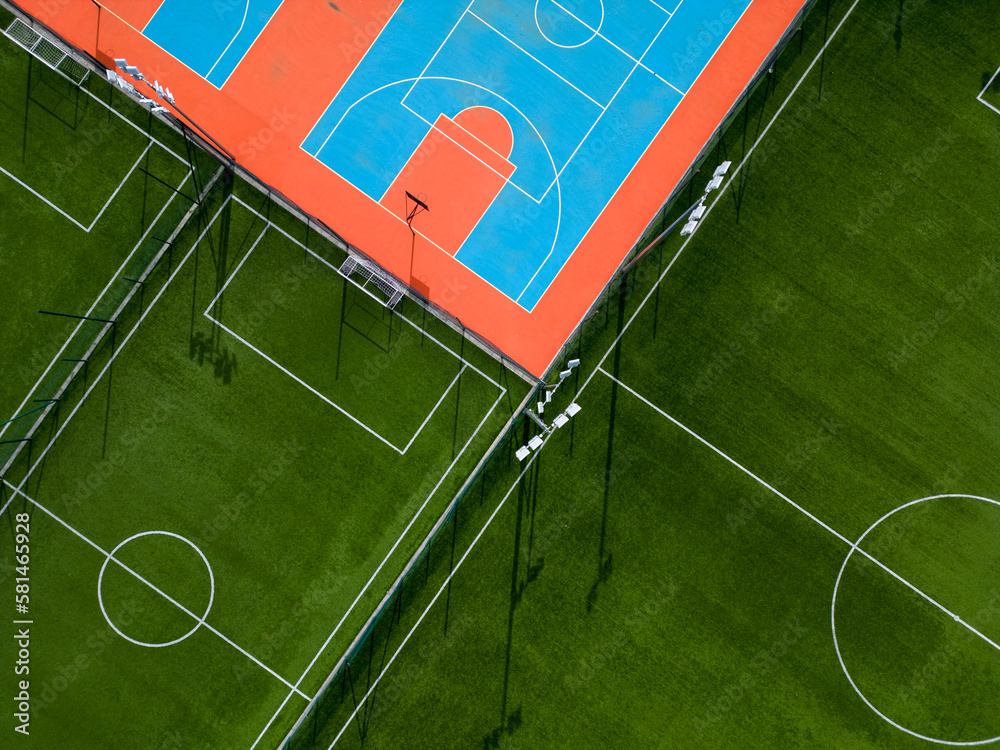 aerial-view-of-a-green-football-field-and-a-colorful-basketball-court